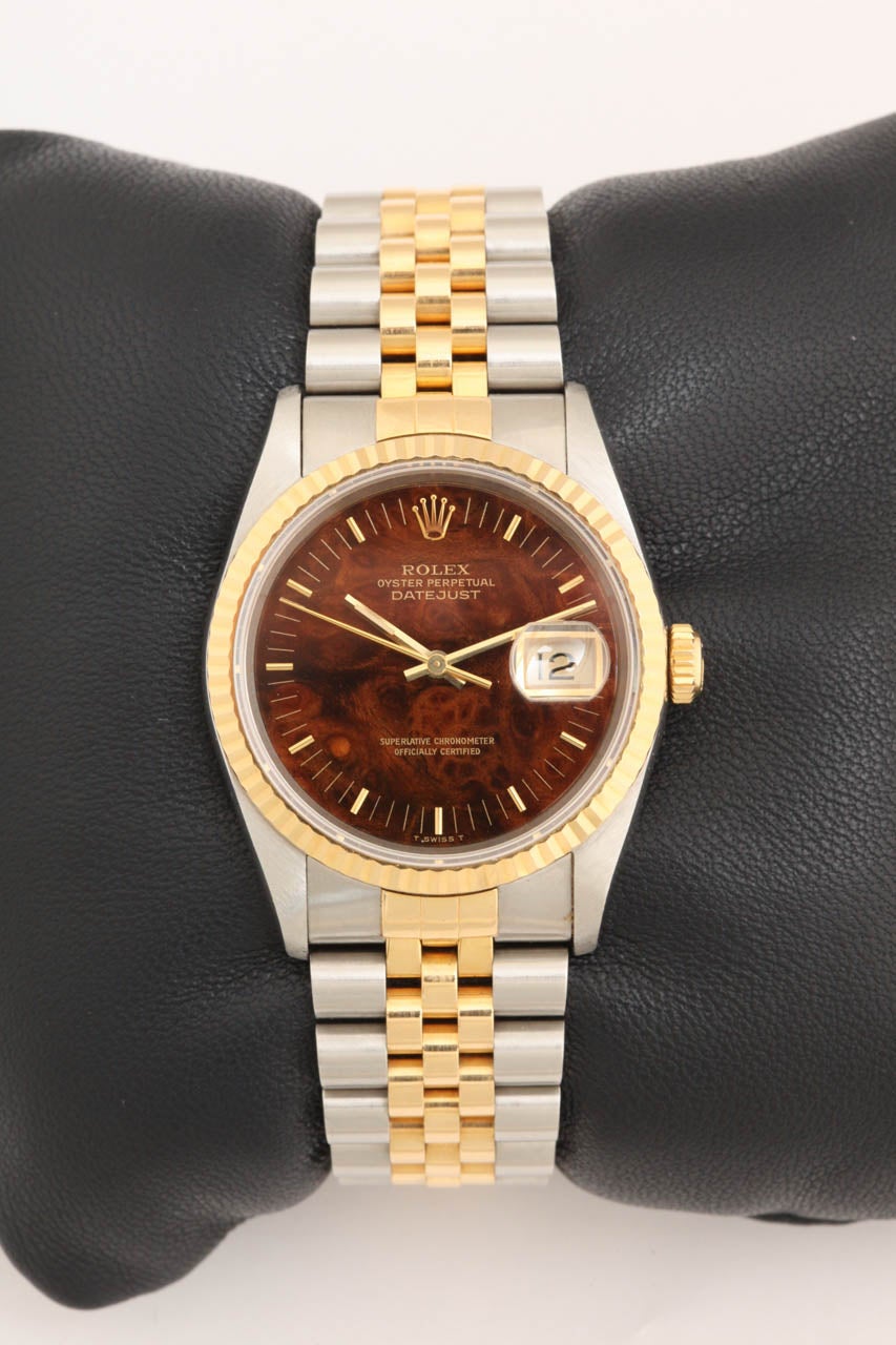 18k yellow gold and stainless steel Rolex Datejust wristwatch with burl wood dial. Ref:16233. Automatic movement. Gold fluted bezel with gold hour markers and hands. Sapphire crystal, quick-set date. 36mm case. Two-tone jubilee bracelet. This watch