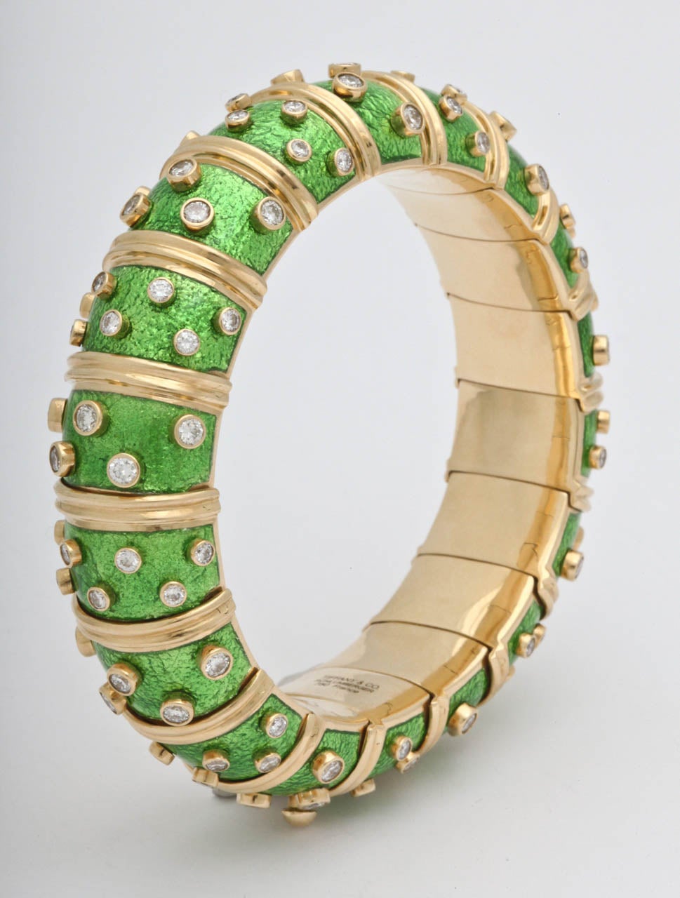 TIFFANY & Co. JEAN SCHLUMBERGER 
Yellow Gold Diamond Light Green Enamel Bangle Bracelet with bezel set round brilliant cut diamond accents. 
Inner circumference - 6 3/4