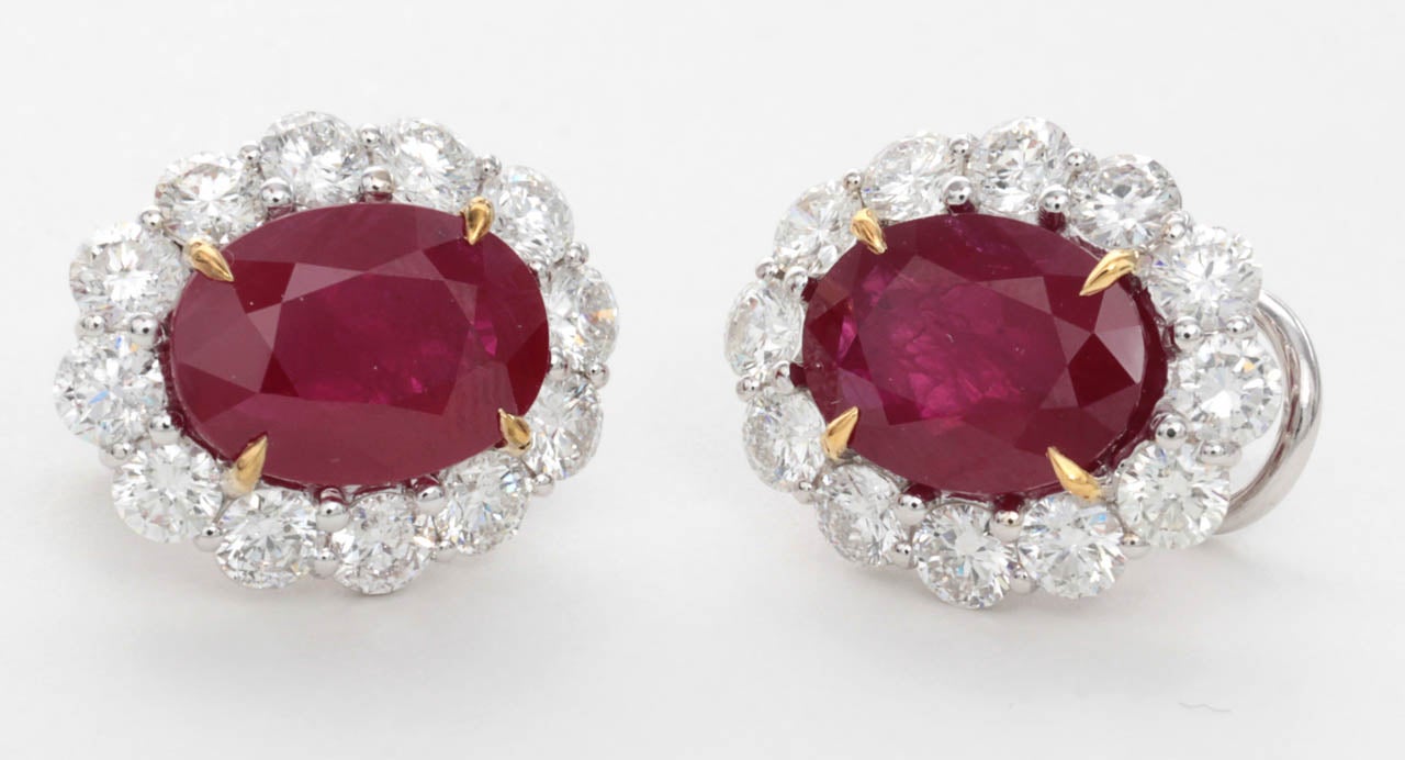 Fine pigeon blood oval shape Burma Ruby earrings surrounded by round brilliant cut diamonds. 

9.38 carats of Burma Ruby, 3.97 carats of round brilliant diamonds.

The earrings are set in a custom made 18k white gold setting.

Certified Burma
