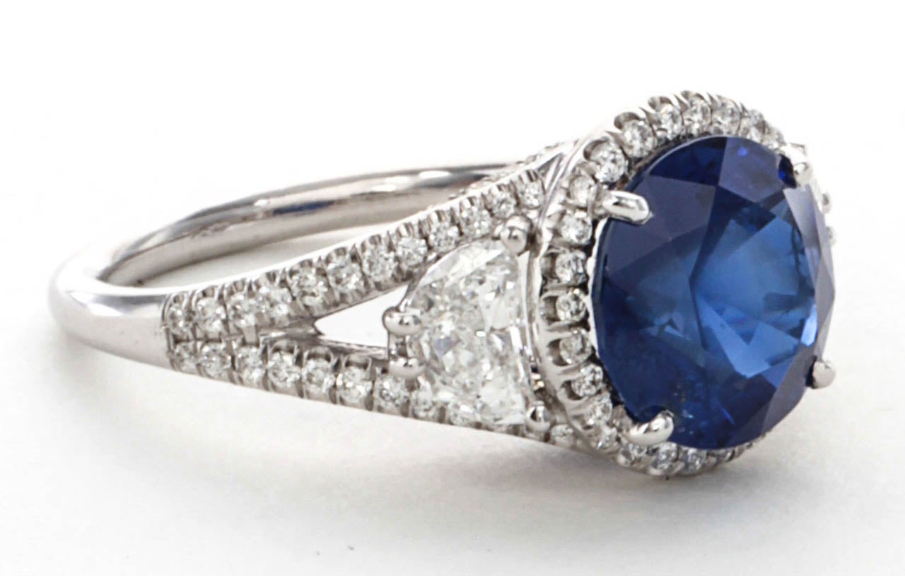 3.45 carat round cut center sapphire. 

The sapphire is certified natural no heat with exquisite cornflower blue color. 

This important sapphire is set in a custom diamond mounting featuring half moon cut side diamonds and micro pave detail set in