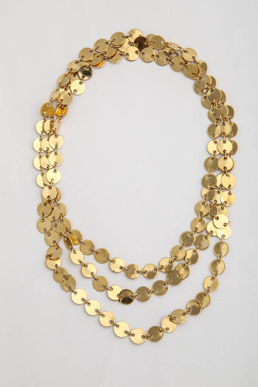 Long collier de petits disques en pierre d'or avec fermoir.