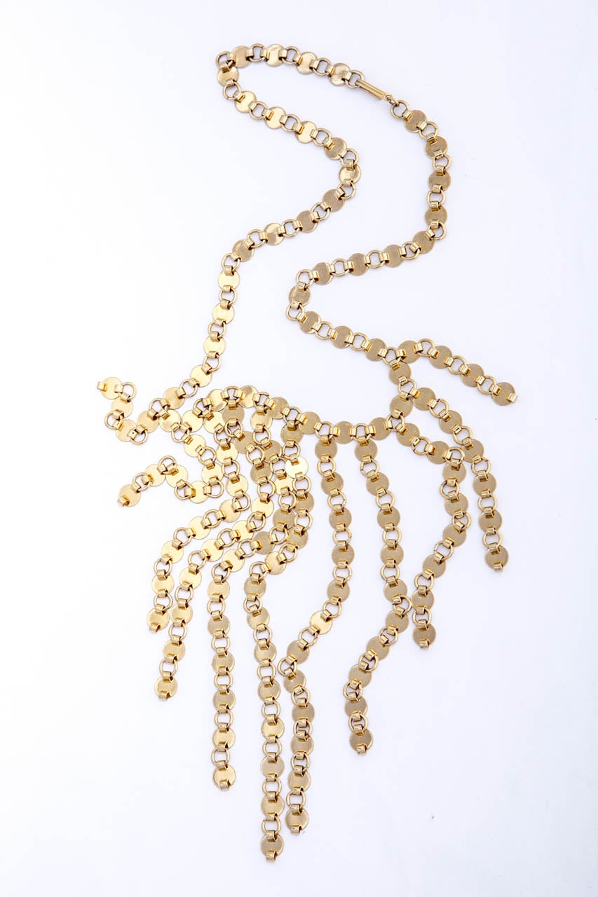 Adjustable length eleven strand tiny goldtone disk bibb necklace.