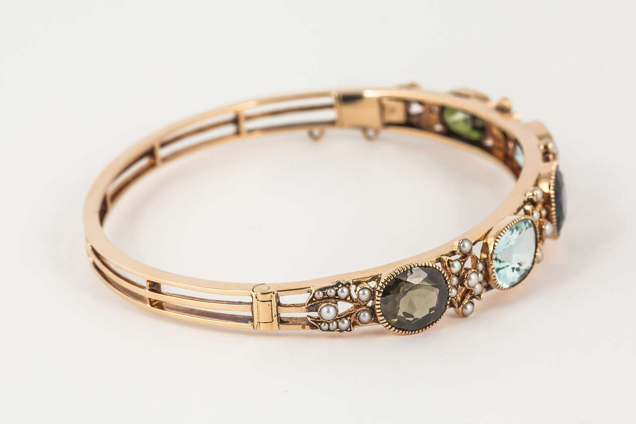 Edwardian 15ct Gold multi gem set bangle with green sapphires, aquamarines, spinels and pearls
