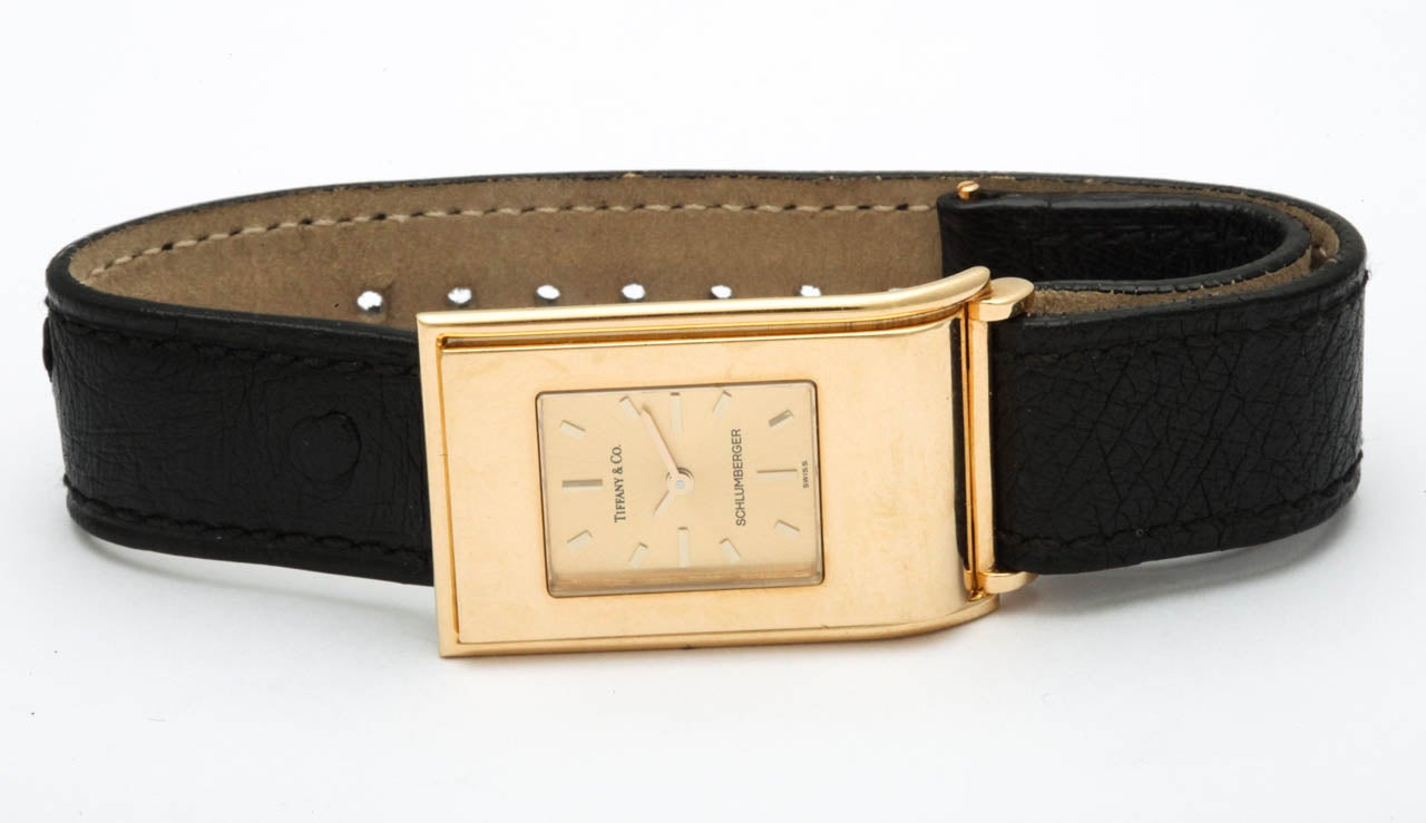 Tiffany & Co. 18k yellow gold rectangular wristwatch designed by Schlumberger, with unusual bezel-buckle.
