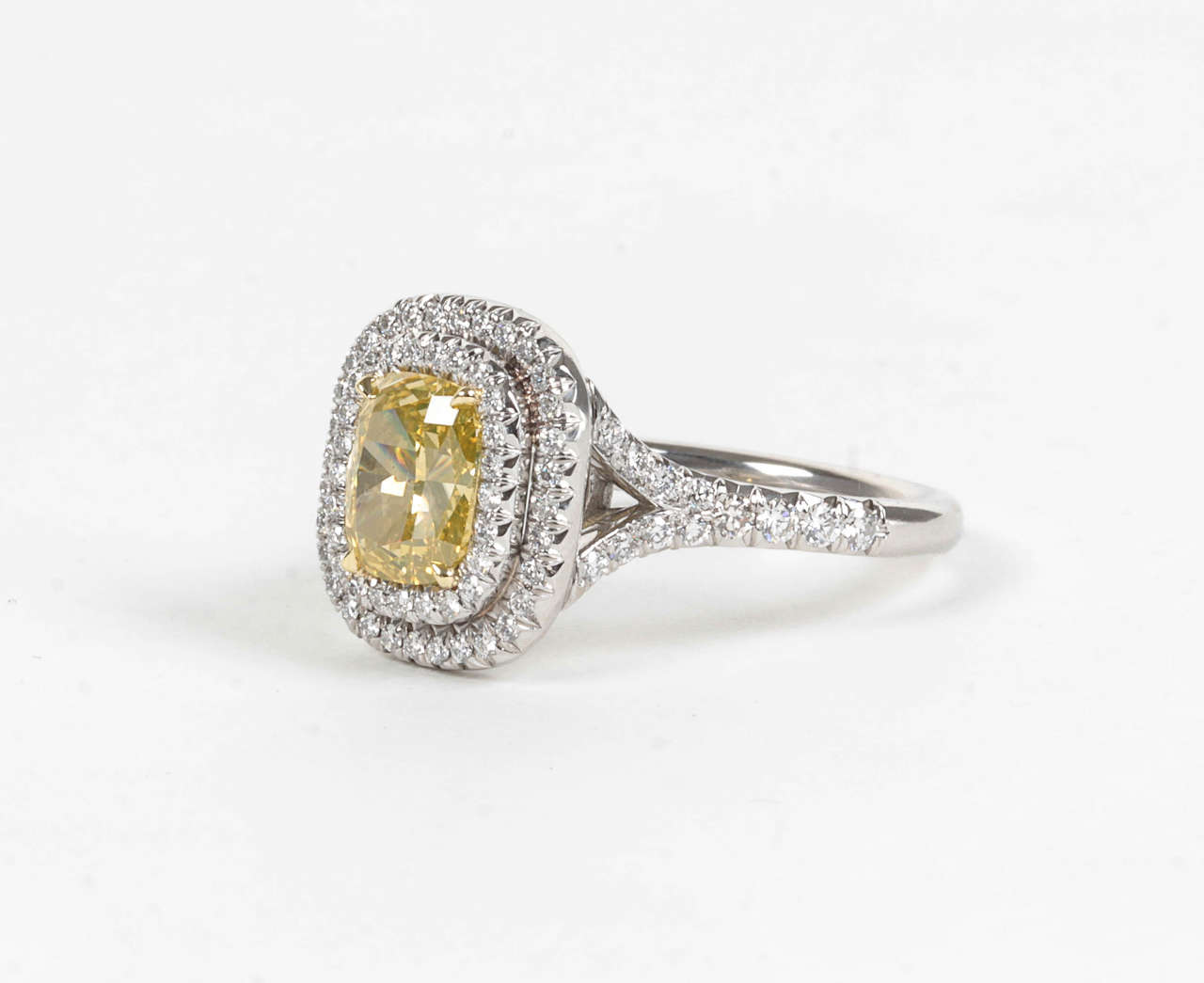 1.54 carat GIA Certified vivid yellow VS2 cushion cut center diamond.

The center diamond is set in a handmade platinum and diamond mounting featuring 0.80 carats of round brilliant cut white diamonds.

A beautiful engagement or cocktail ring to