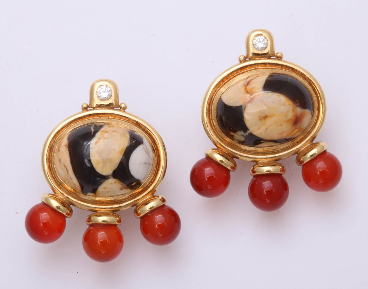 Striking Medieval style Earrings by Elizabeth Gage.  Oval Fossilized cabochon stones circled in 18kt Yellow Gold & crowned by a full cut Diamond & offset by 3 round Carnelian beads. Simply - pure power.