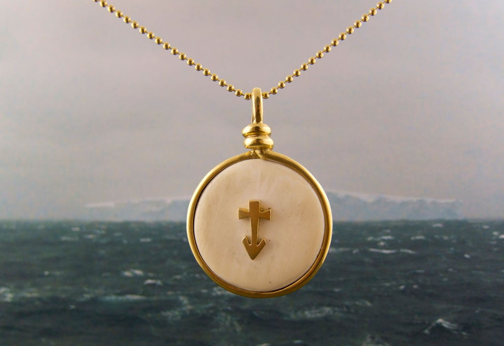 Made in 18K yellow gold and bone. This collectible pendant consists of a bone disc surrounded by gold forming a sailor's knot. Center is an anchor/cross originally used by the early Christians in the Catacombs. Pendant is 1 3/4 in diameter.<br