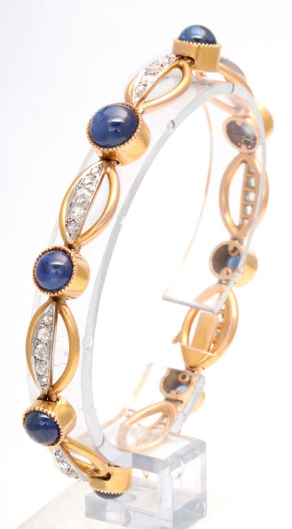 Beautiful 18k yellow gold bracelet featuring oval links with Rose cut diamond bars connected by cabochon sapphire buttons.