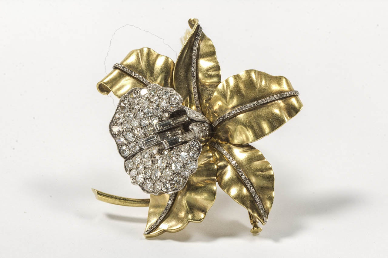 Designed as an orchid with finely shaped leaves, decorated with single-cut diamonds and center decorated with single and old-European-cut diamonds and baguettes. French marks.