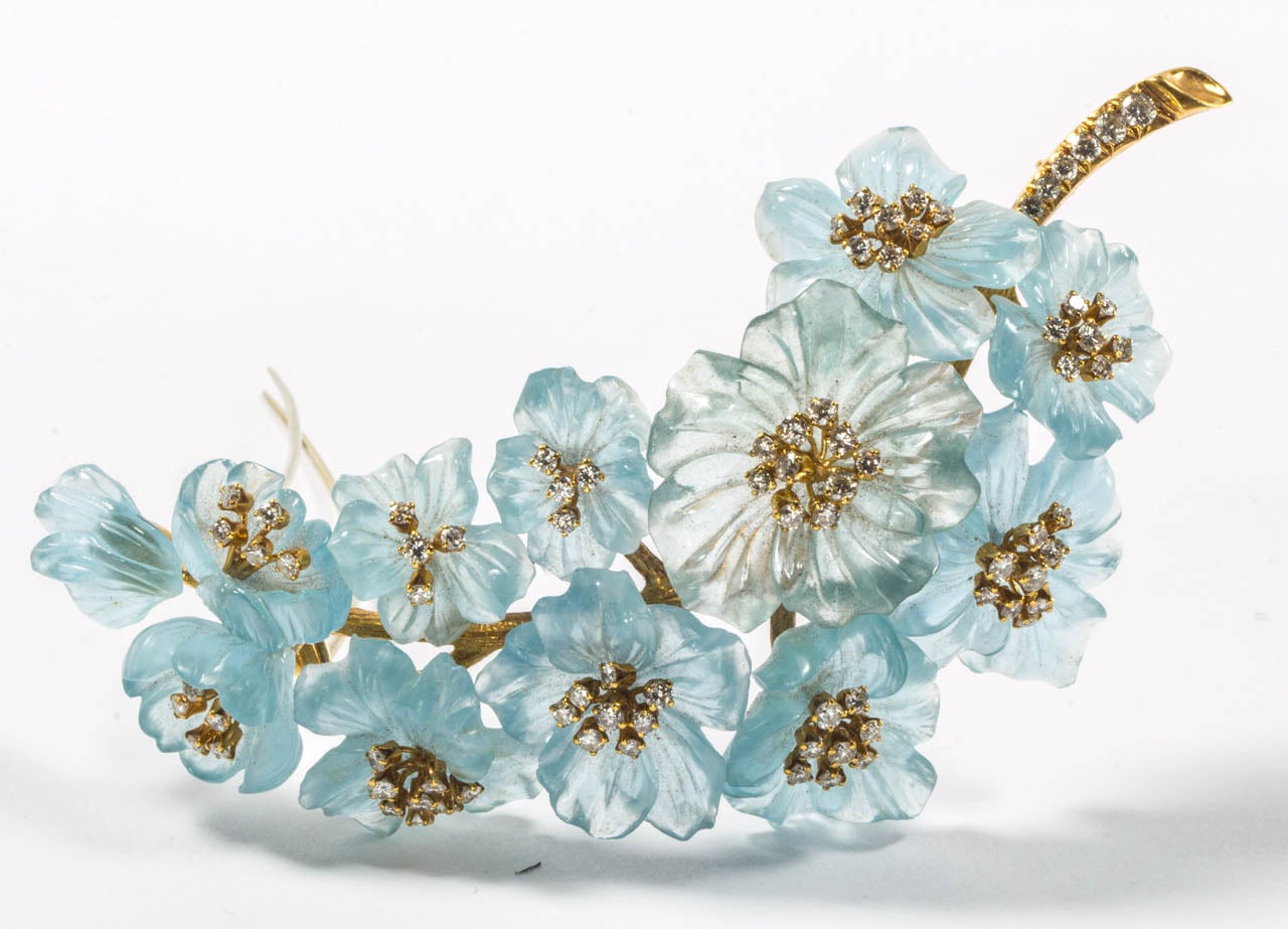 Designed as a carved gold branch decorated with carved aquamarine flowers and brilliant-cut diamonds.