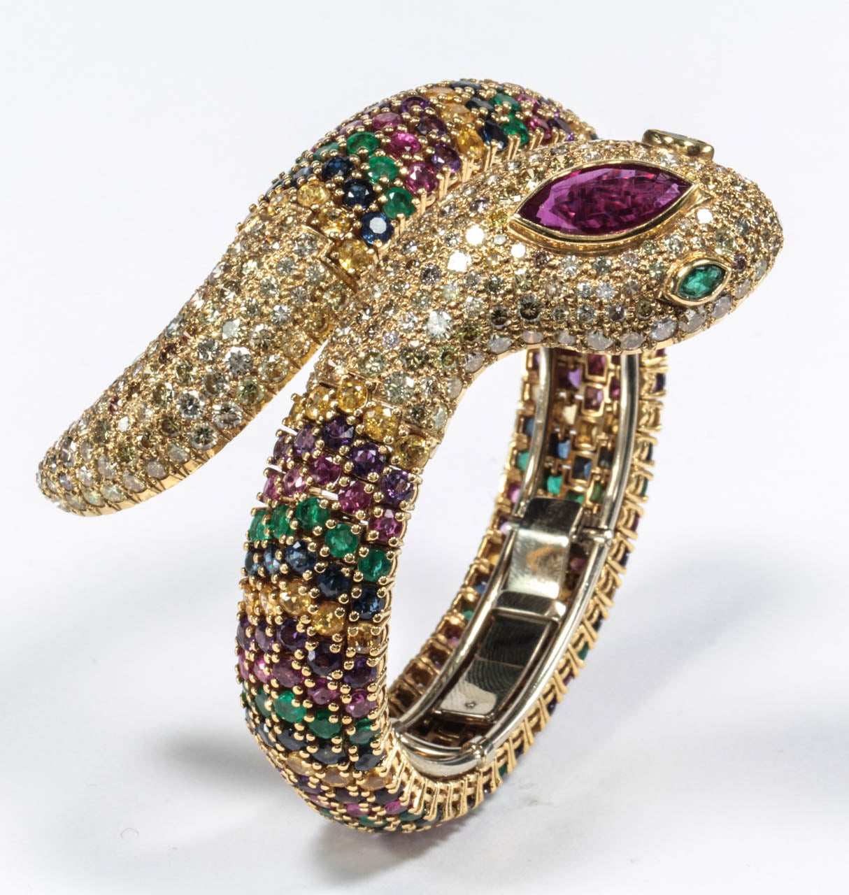 The articulated body set with circular Rubies, Amethysts, Yellow Sapphires, Blue Sapphires and Emeralds, the head and tail decorated with brilliant-cut diamonds, the head set with a marquise-shaped Ruby and similarly-cut Emerald eyes.