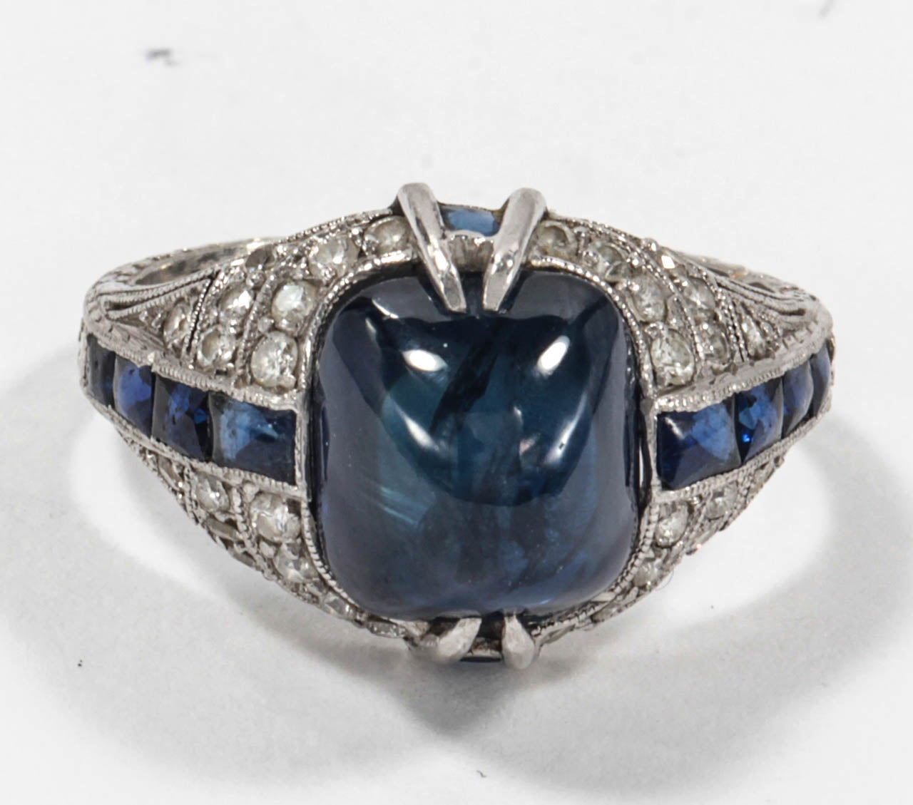Set with a sugarloaf sapphire surrounded by a line of French-cut sapphires and brilliant-cut diamonds