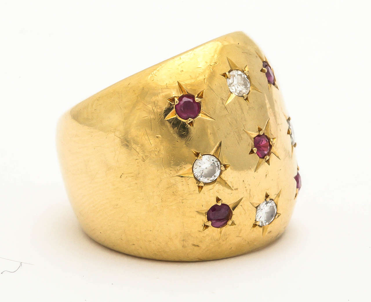 18kt yellow gold high polish large and wide gold band ring consisting of five beautiful color faceted rubies set in stars and four full cut diamonds set in stars ring is American made in the late 1940's Ring Size 6 may be sized to any ring size