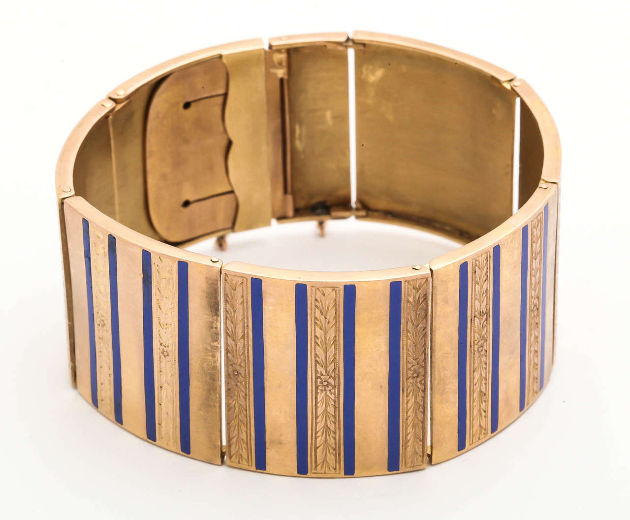 18kt gold and alternating floral hand engraved and solid polished strip panels designed with alternating periwinkle blue enamel stripes flexible bangle bracelet designed with hinges thruout bracelet for extra flexibility. Beautifully made with an