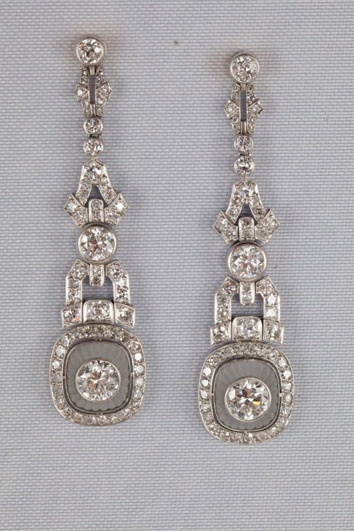Each earring centers 1 bezel-set transitional-cut diamond within a fluted dome of rock crystal surrounded by  bead-set single-cut diamonds, suspended from a flexible column composed of geometric shapes set with old European-cut, rose-cut and