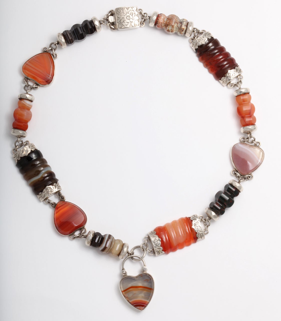 Carved and ridged banded agate and carnelian is set in engraved sterling then linked and interspersed with agate hearts. The original clasp on this necklace is intact as is the floral engraved padlock with the same engraving that will sit near your