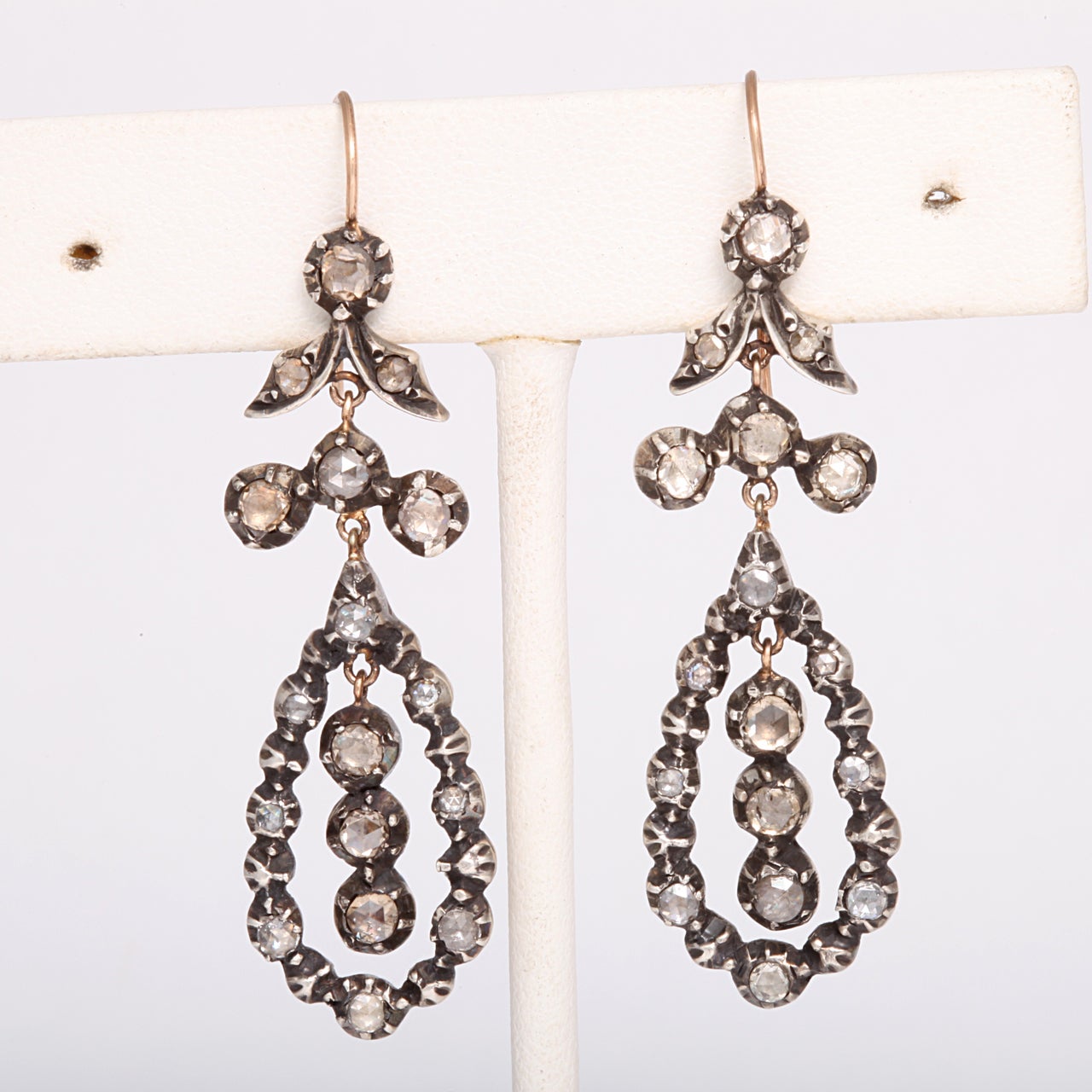 Early 19th century diamond earrings are set with forty six bright rose cut gems in a manner suggesting a floral and dew drop motif. The advantage of owning antique diamonds is in the resulting effect that the period played in the cut of the stones.