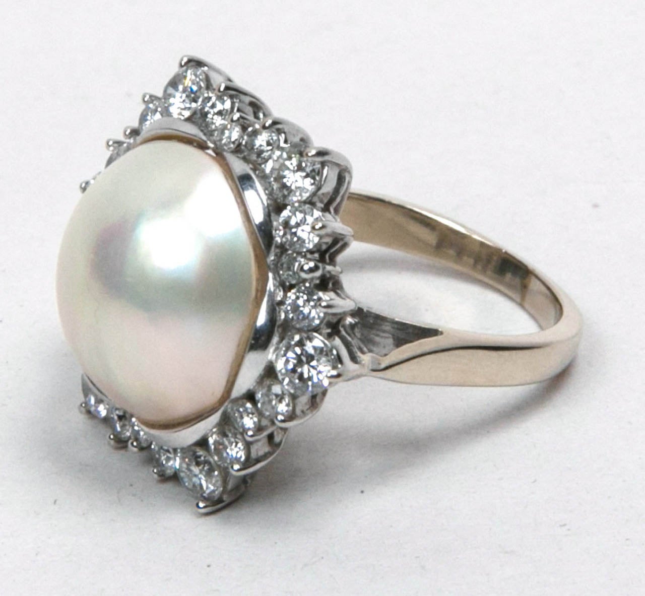 15mm Mobe Pearl Ring with 24 Surrounding Diamonds Set In 18k White Gold.
1.70ct
size 6.5 / 7