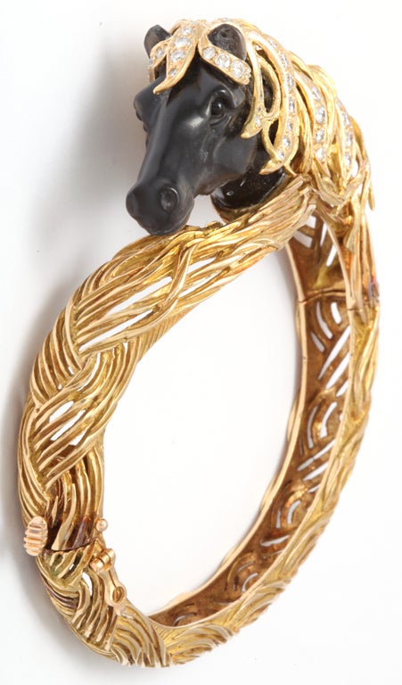 seabiscuit horse bangle made of 18kt gold and diamonds wiyh dark mother of pearl carved stone in a horse figure