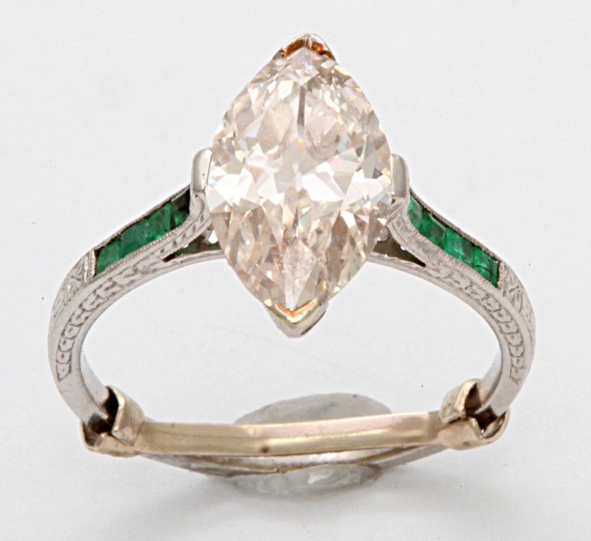 A French Deco Marquise cut diamond engagement ring. This wonderful 2.65 ct diamond (VVS,  I )  ring is surrounded with square cut emeralds and single cut diamond accents mounted on a handcrafted platinum ring. App avail.