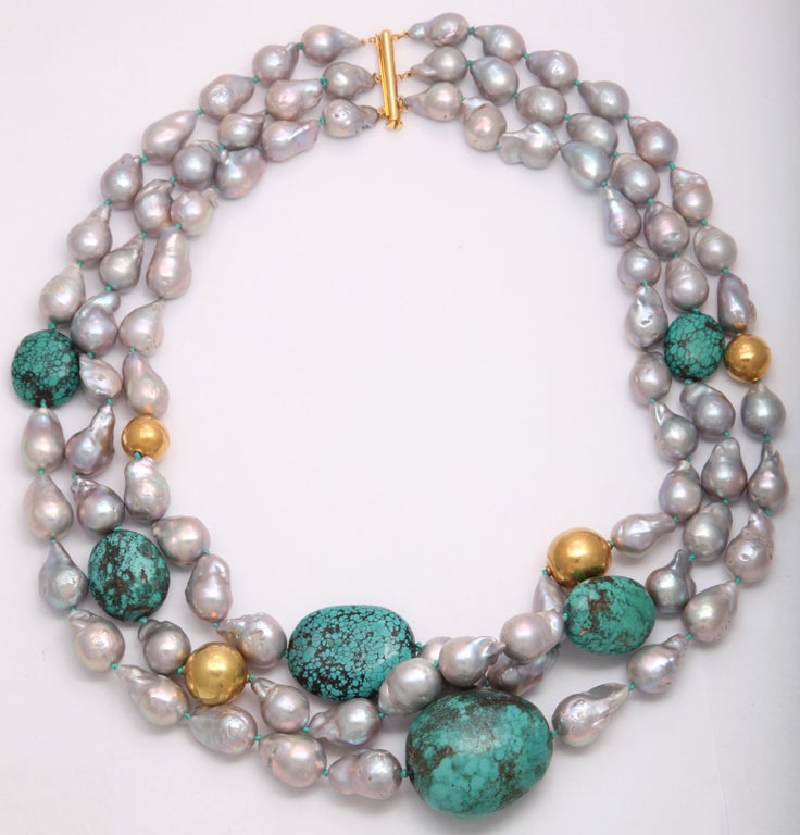 Three strands of very large natural pearls with rare turquoise rocks and 22kt yellow-gold beads.

Overall length: 27