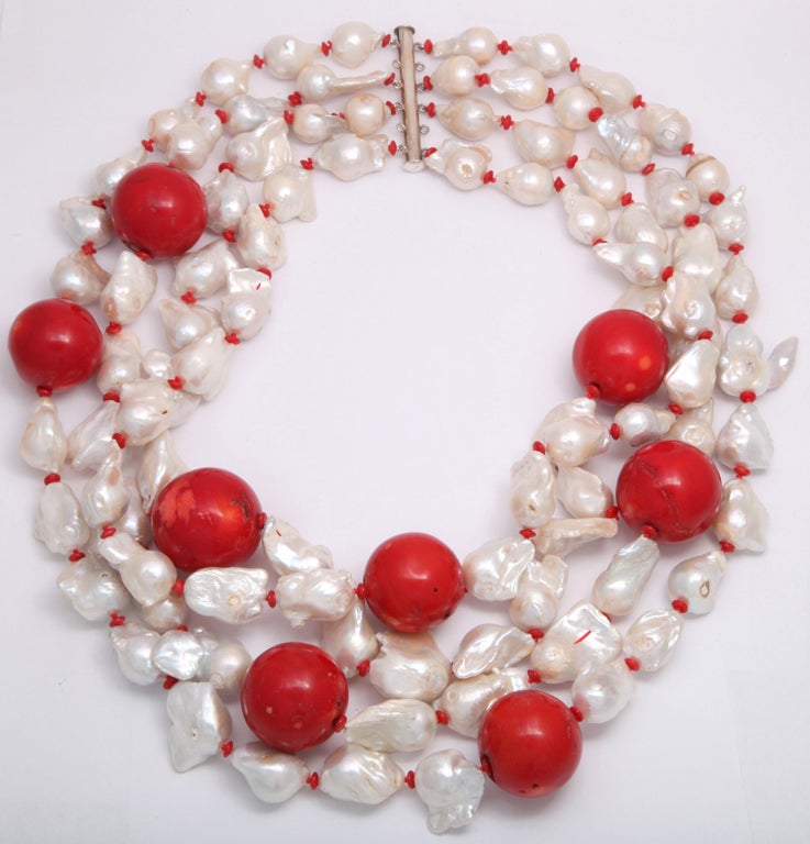 Three strands of exaggerated size Pearls with eight giant Coral balls. 

Length: 27