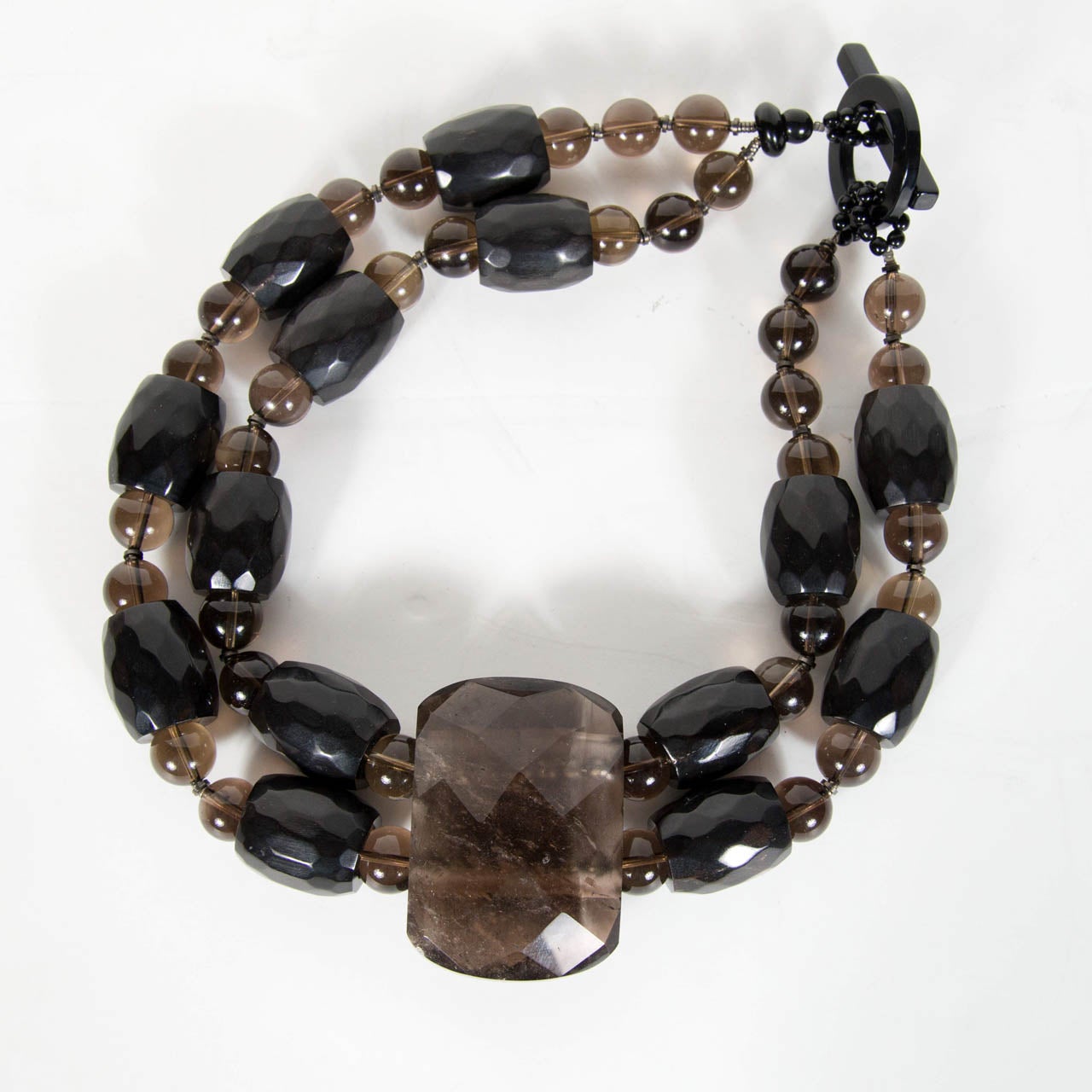 This very chic necklace is made of smoky quartz and smoked glass beads with a clasp that is signed Giorgio Armani.