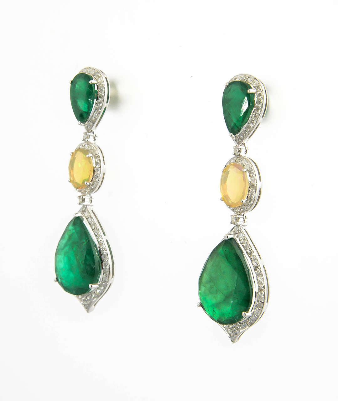 These earring are beautiful on the ear.  The emerald and opals hang in diamond frames mounted in 18k white gold.  The earrings have a post back.