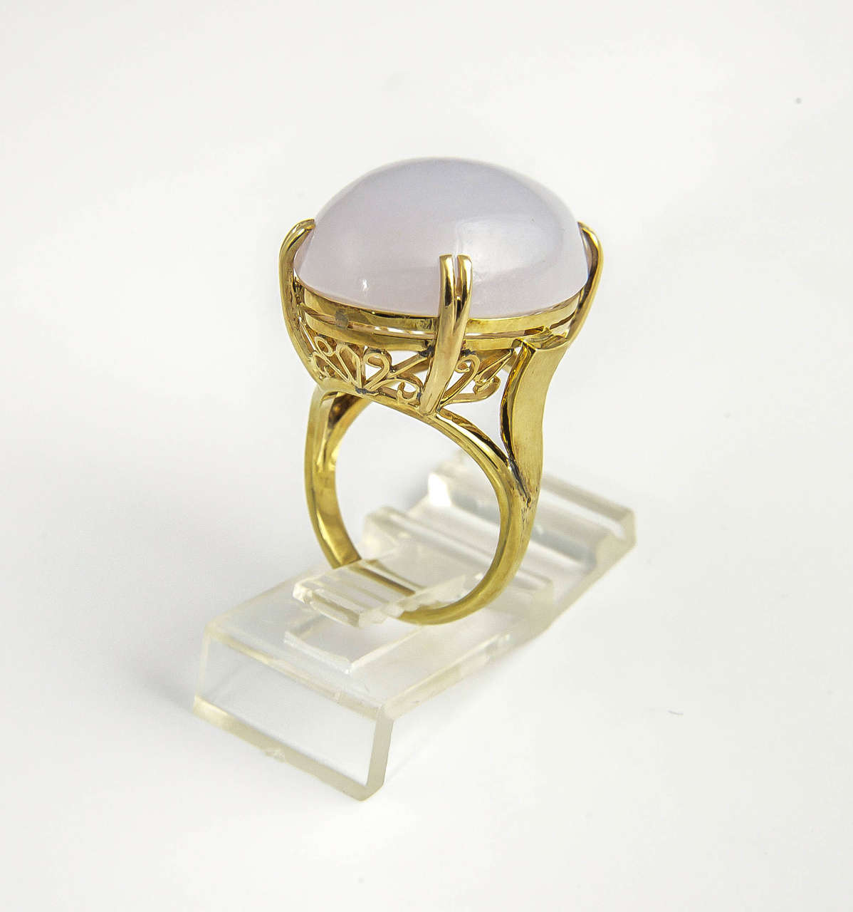 Lovely piece of lavender jade mounted in a 14k yellow gold mounting.  The mounting has beautiful design work along the bottom.

US size 6 - 6.25