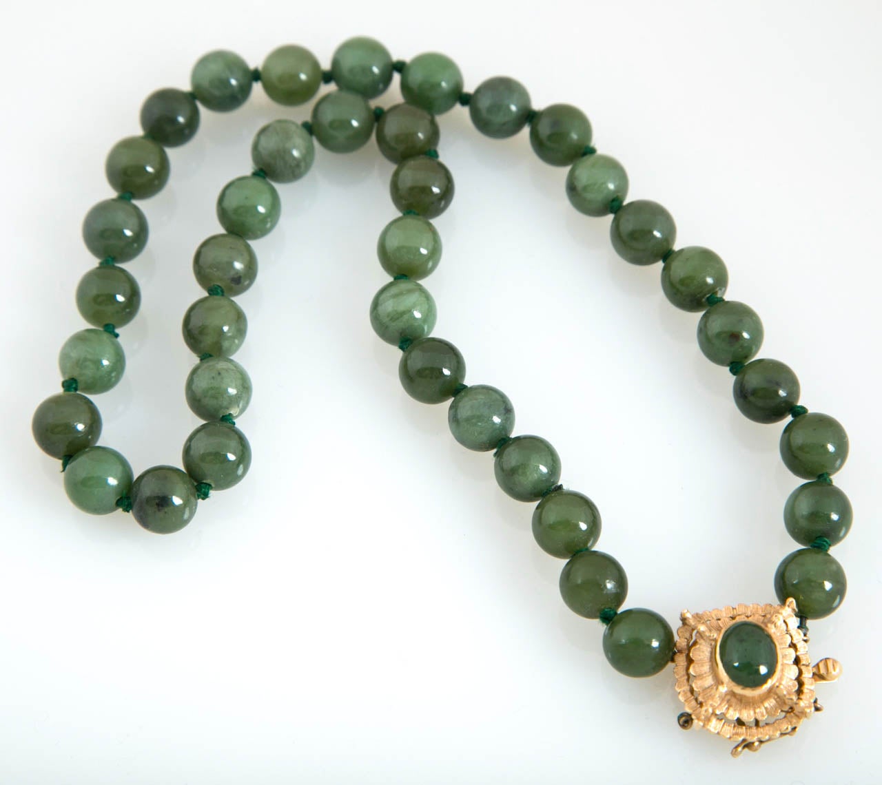 Spinach green jade necklace from the 1960s. Clasp is 14kt gold. 

Substantial dramatic Asian motif. Length is 18 inches.