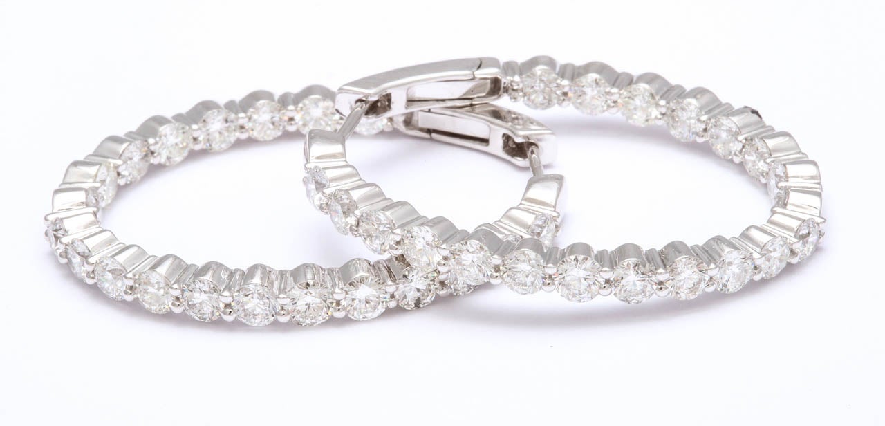 Classic oval shape hoop earrings featuring 40 high quality diamonds weighing 5.23 carats, in 18k white gold. Great safety clasp!