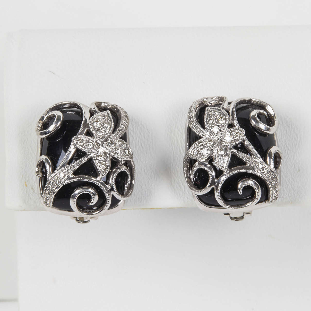These earrings can be worn as just a clip or a post and clip, the post is hinged  and can lay flat. The butterfly and scroll design is very feminine yet the black onyx and white  gold combination is strong and bold. These are very easy to wear in