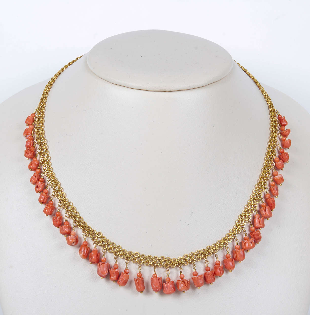 Beautifully carved coral tulips, in a bright orange color, are suspended from an 18 kt chain link necklace. Total length is 16 3/4 inches. Matching earrings are J150319696116.