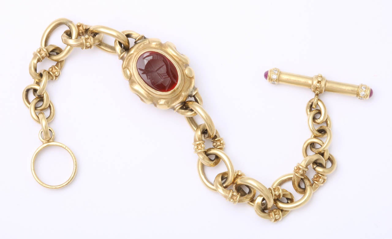 18kt Yellow Gold handmade Bracelet with circle & Toggle closing.  Link alternates with a plain oval & decorated oval.  There is a chrysophrase & Carnelian charm which is decorated with two Intaglios of classical heads.