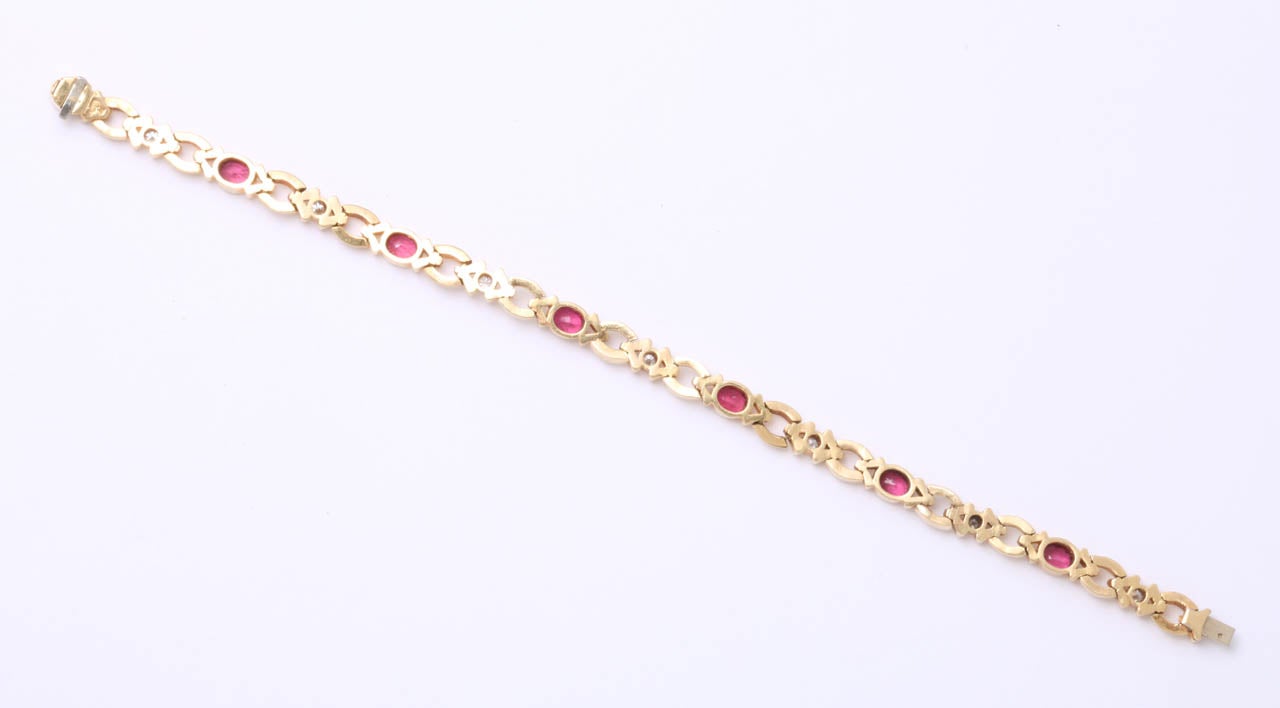 Seven Oval Faceted Rubies set in 18kt Yellow Gold & separated by full cut Diamonds set in  Segments.