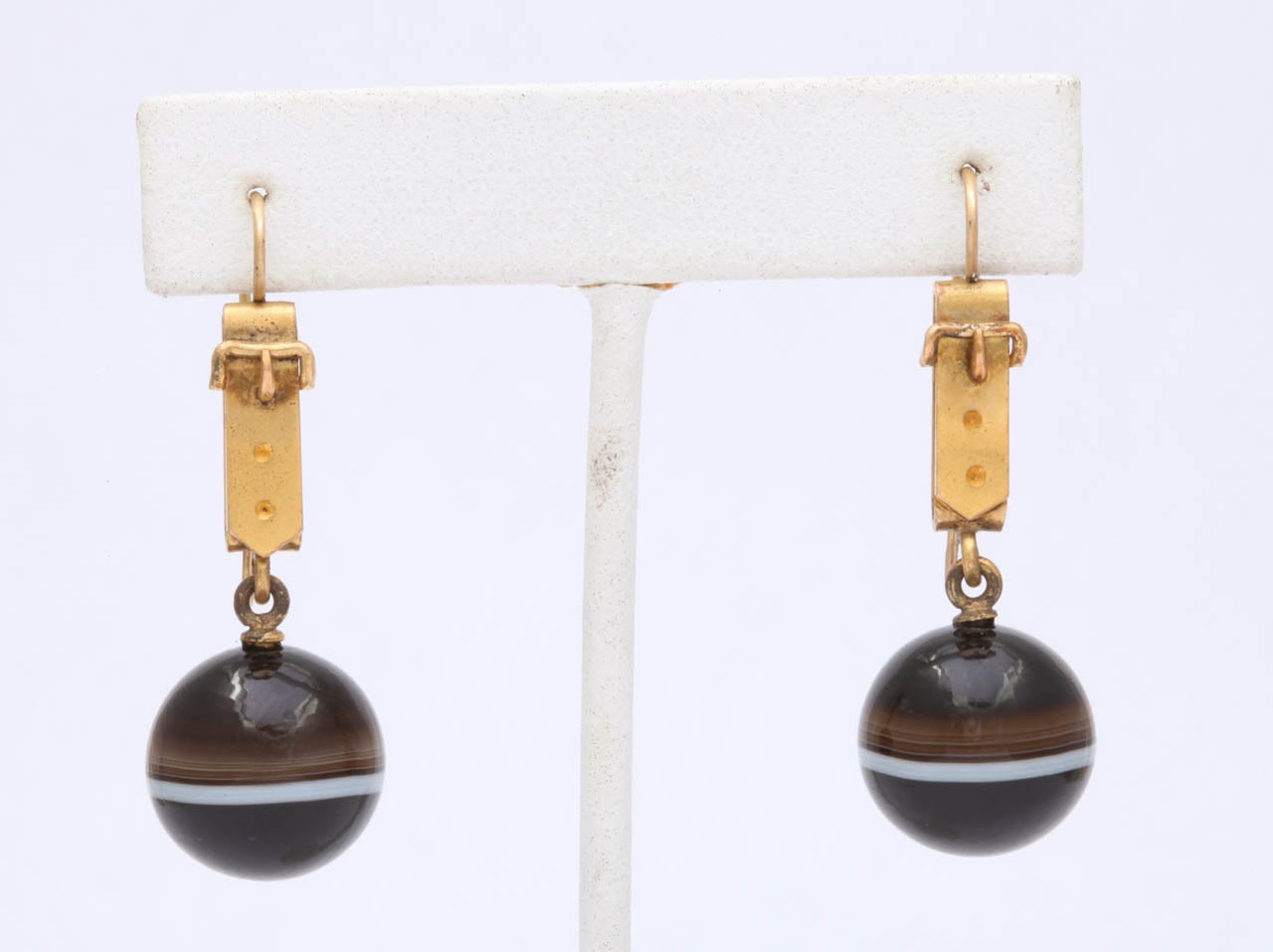 One of the many design characteristics in 1870 Great Britain was whimsy and humor, both of which are present in these belted banded agate earrings. A buckle on the ears or wrist, a corset on a bracelet, bangles that appear to be shirt cuffs with