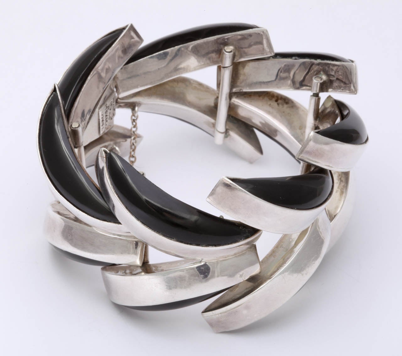 Spectacular and futuristic are words that apply equally to this striking bracelet. The contrast of silver and black is clean and dramatic. Combined here in huge chevron or v shaped links, both design and color give this 1950's bracelet a timeless