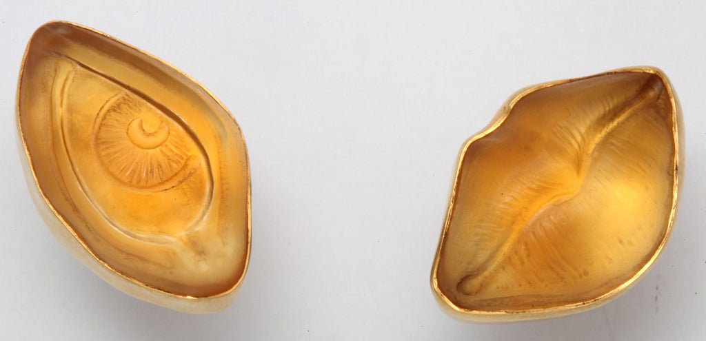 A pair of earrings composed of a hand carved citrine eye and a hand carved citrine mouth. Each stone has been bezel set in 18kt yellow gold. The back of the earrings mimic the front of the stones. They are composed of an 18kt yellow gold eye and an