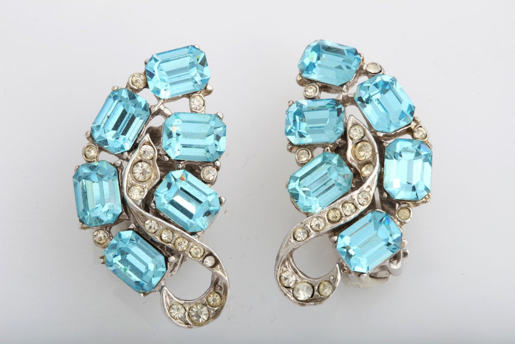 Emerald cut turquoise colored stones and round rhinestones set in silvertone clip earrings.