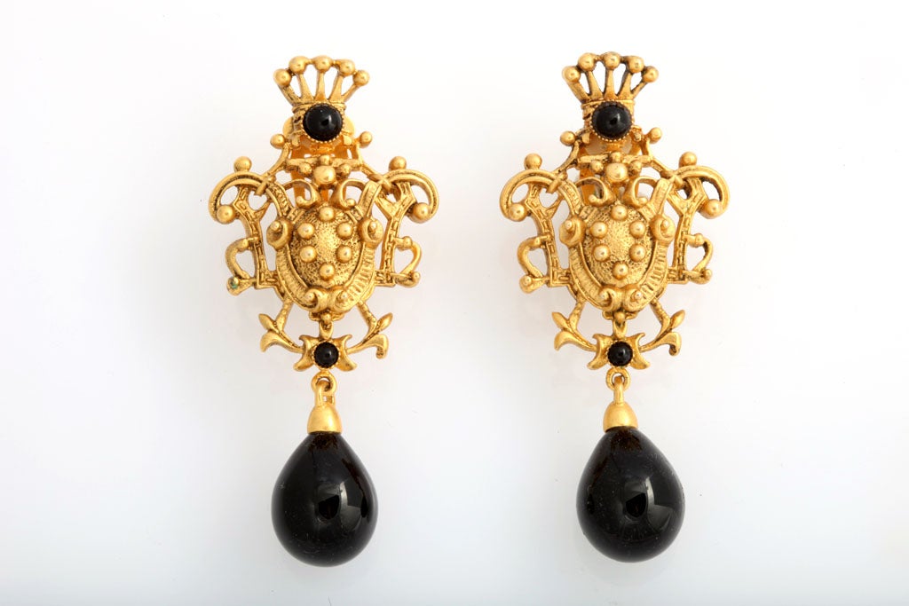 Nicely detailed goldtone crest earrings with two small black cabochons and one black teardrop stone.