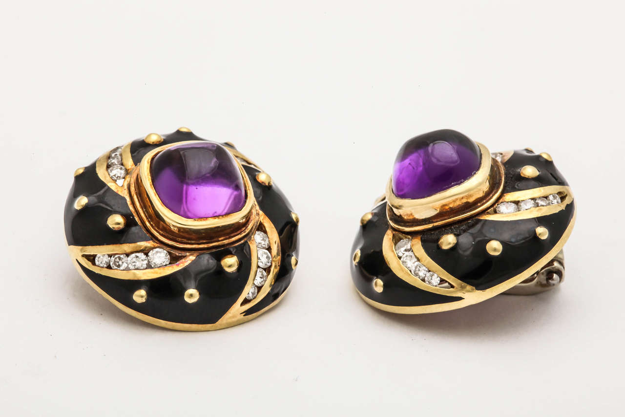 18kt yellow gold studded earclips consisting of 2 cabochon high quality amethysts and numerous full cut  high quality diamonds set with a black enamel and gold setting in the shape of a pinwheel design to create an optical illusion of movement
