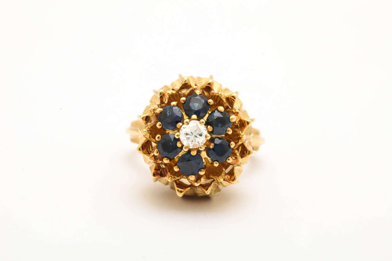 18kt yellow gold hand engraved cocktail ring in the shape of a figural tulip flower embellished with 6 beautiful color faceted sapphires and centering a .25pt high quality full cut diamond, Made in the 1950s in America.