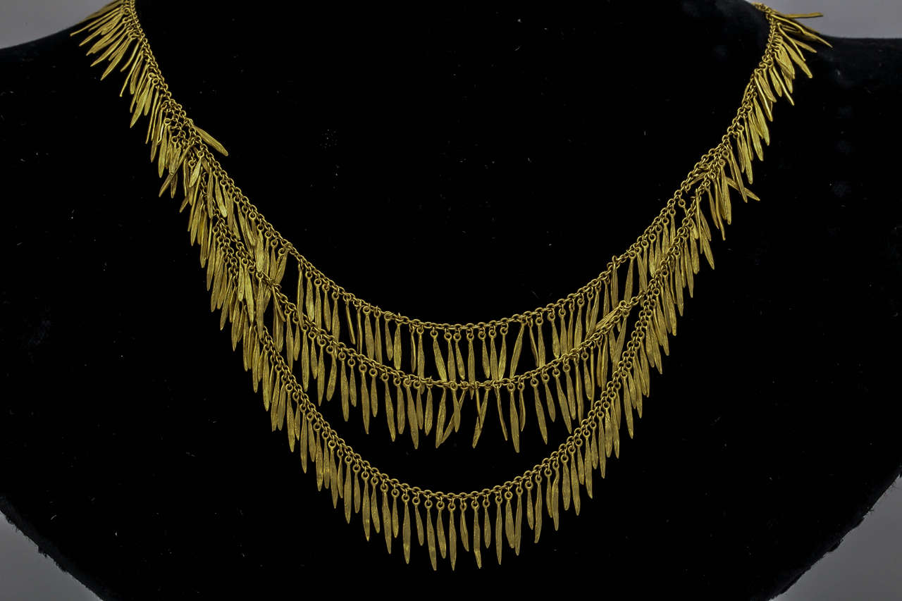 18kt yellow gold tribal design fringe tassel necklace consisting of numerous individually set gold hanging artistic pieces to crate movement and flexibility when worn Triple layer tassel effect which is a very hip and modern look perfect for