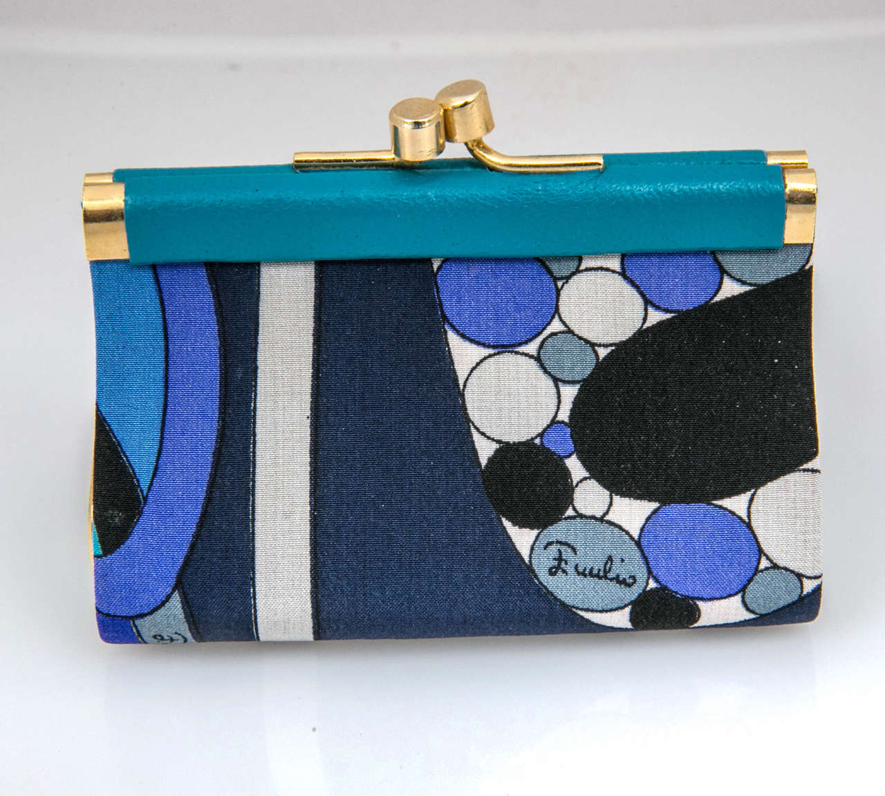 never used vintage pucci coin purse featuring a silk blend modernist print surround with turquoise leather accents. features 3 'emilio' signatures within the motif: rare on a small change purse. classic brass kiss lock closure.