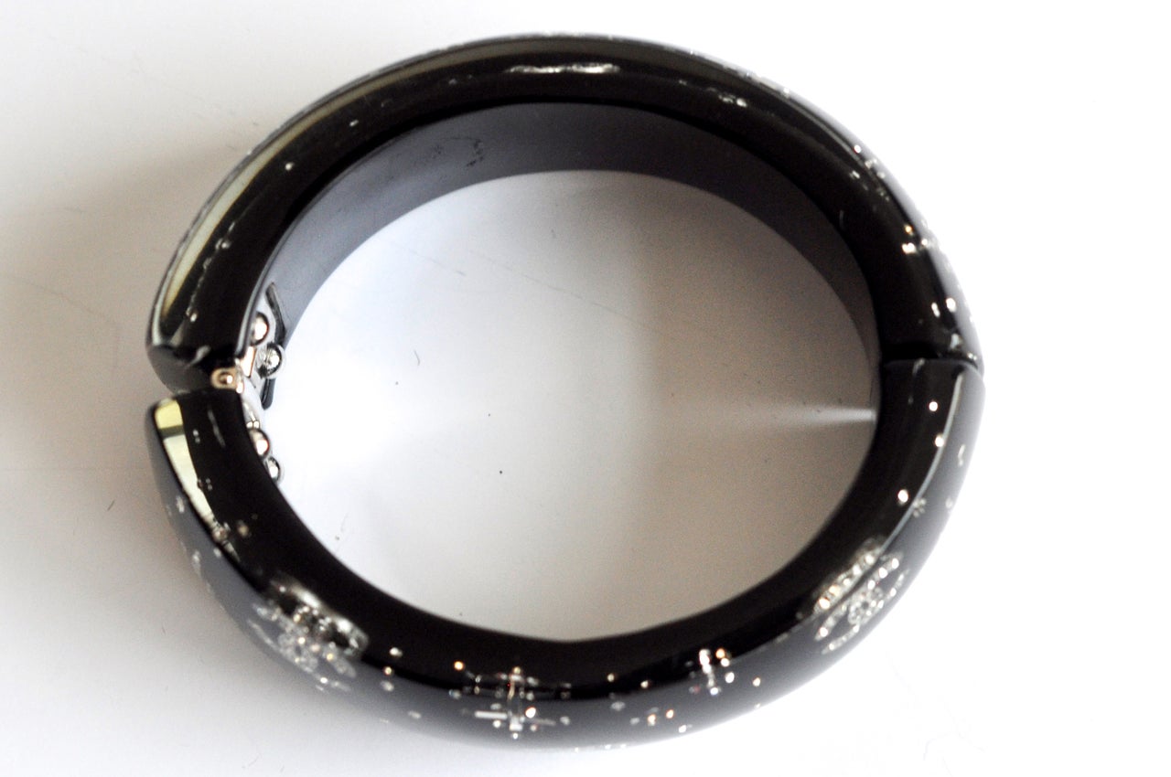 Sophisticated black resin cuff with stylized star and Chanel logo motif.  Fits a smaller wrist perfectly. Marked and dated.