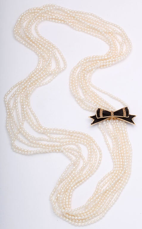This piece reminds me of Chanel.  The Victorian bow brooch and the necklace can be worn together or seperately.  The bow has ribbon and seed pearls mounted in 14kyg.  The necklace has 8 strands of seed pearls with a 14k bar that you can put a pin