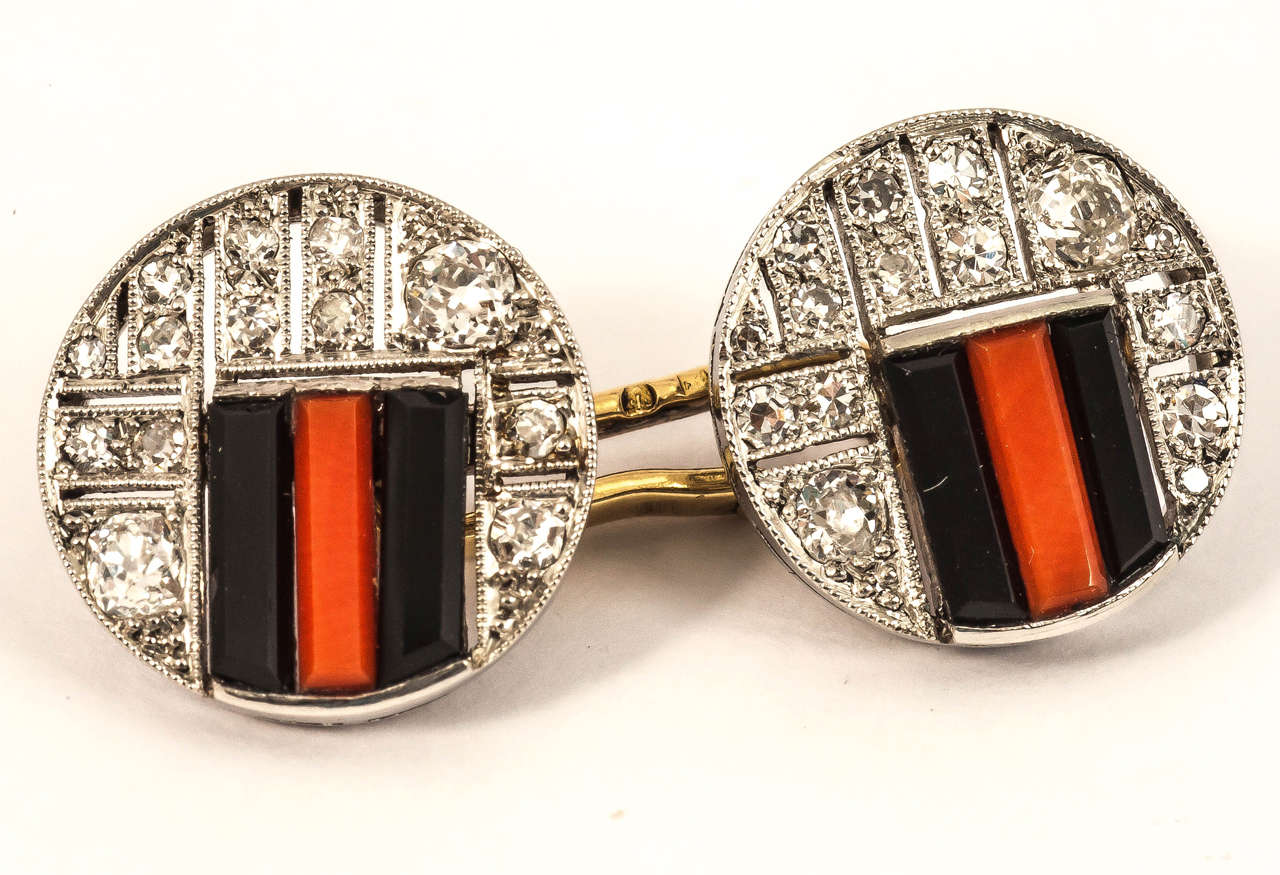 Pair of French marked Art Deco cufflinks mounted in platinum of openwork design set with brilliant cut diamonds,onyx and coral. Circa 1930.