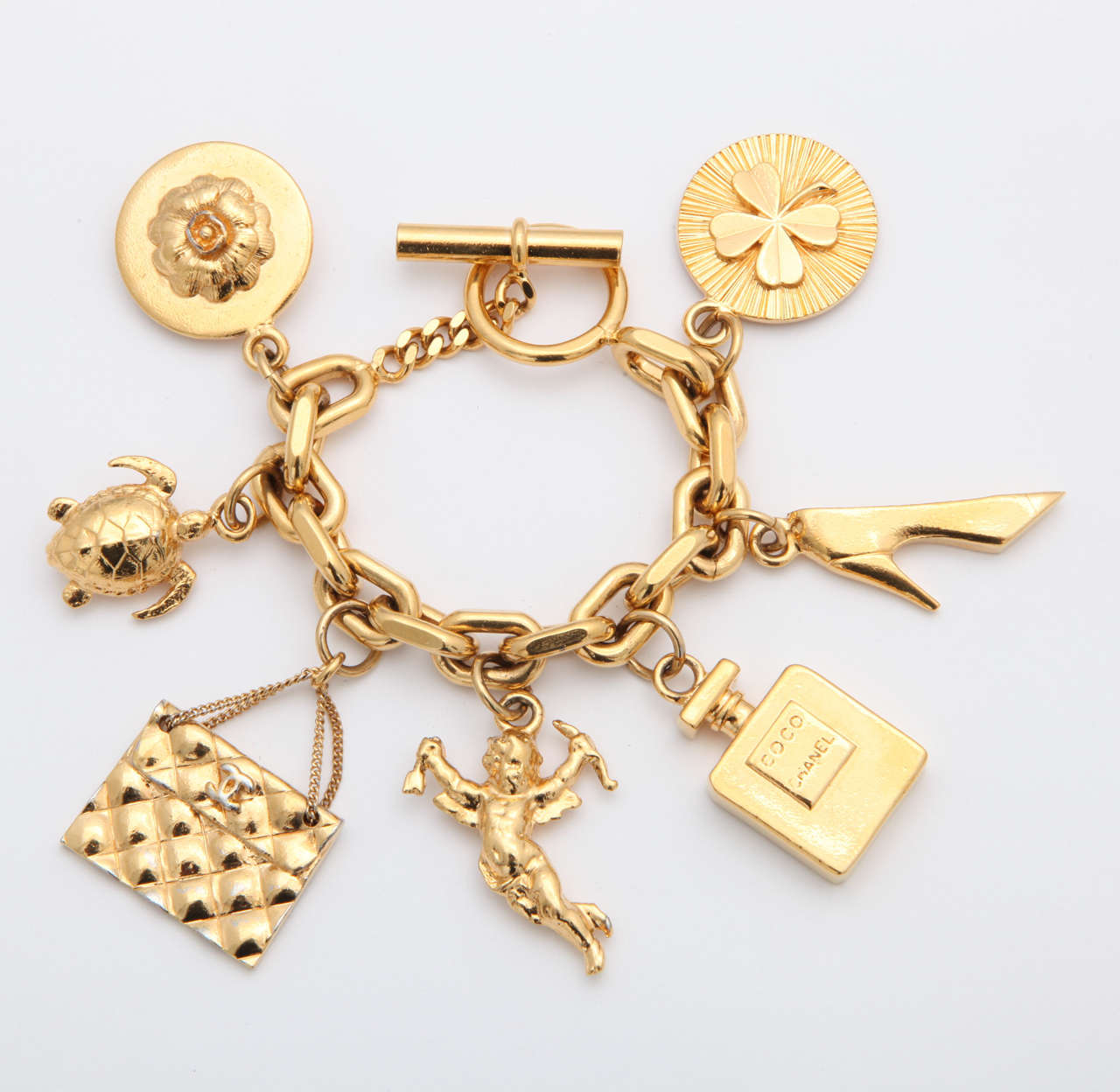 Vintage Chanel iconic 7 charm bracelet. The motif includes Chanel bag, shoes, Coco perfume bottle, angel, clover. Stamped Chanel 2 3 Made in France.

The chain length: 7.5 inches, the round clover motif 1.2 inch in diameter.