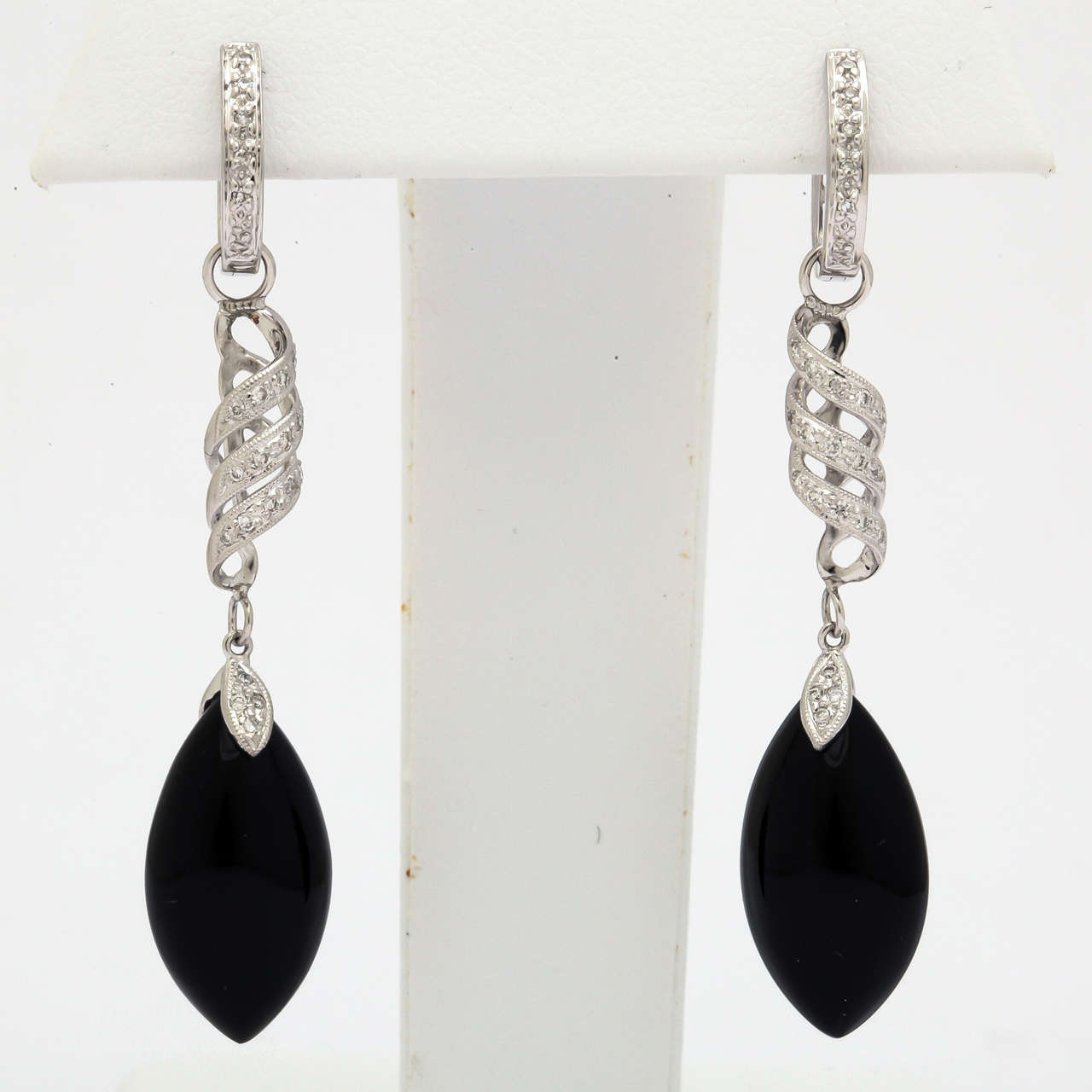 These beautiful dangling earrings can convert to simple huggies. The diamond swirl and black onyx drop can easily be removed and replaced. Other earring charms can be custom made and added to match a particular outfit. These earrings are made of 18