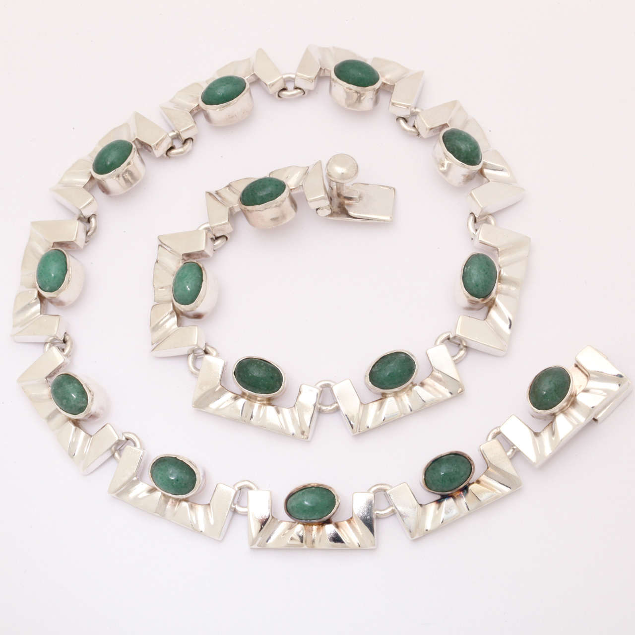 This necklace is an excellent example of vintage handmade Mexican silver from Taxco. It is stamped with 2 pine trees , 925, ts-30. Two trees was an excellent shop in Taxco that produced magnificent, bold pieces. The green stones are aventurine cabs